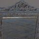 Chic and stylish old mirror with carved wooden frame in limed white and gold