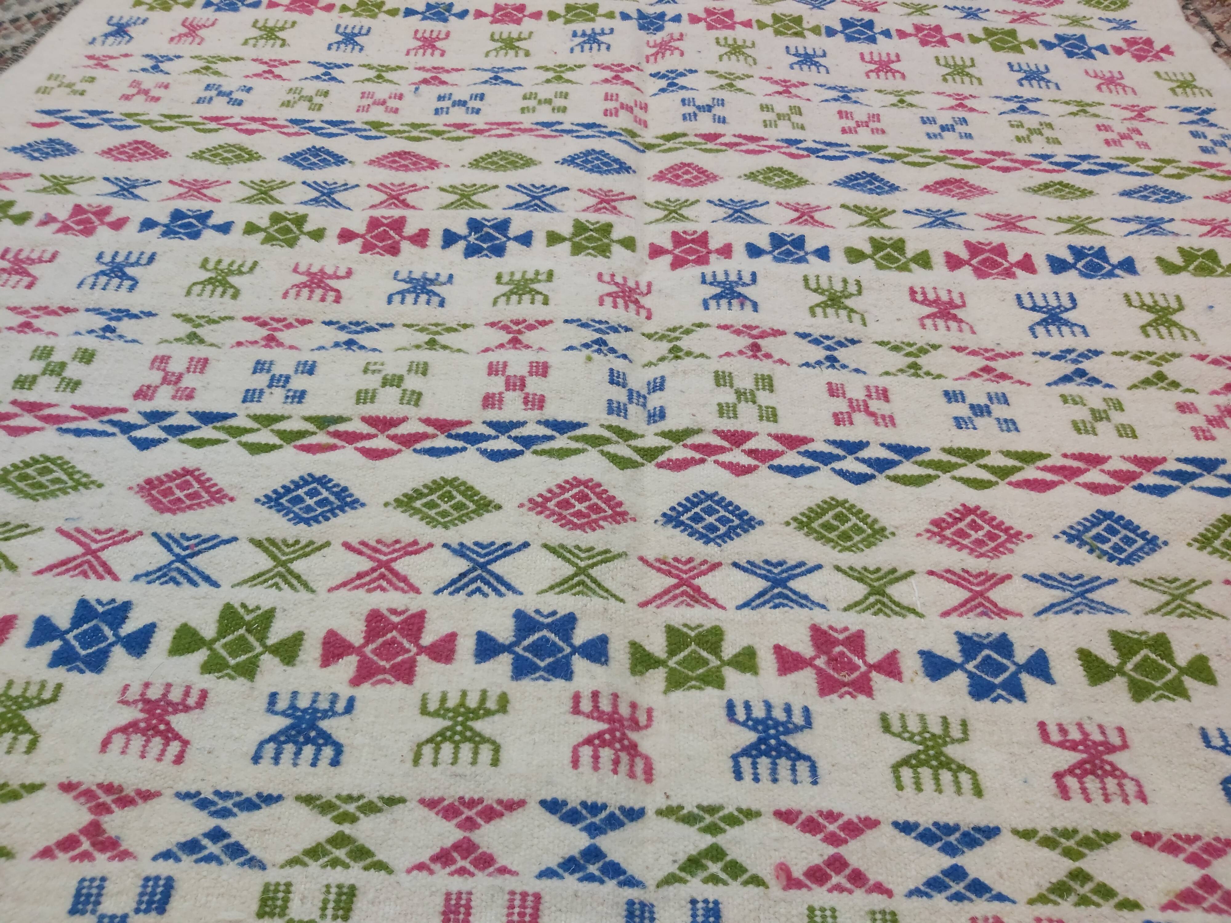 White carpet with Berber motifs pink green and blue