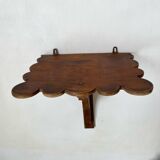 Antique wall shelf with a scalloped edge.