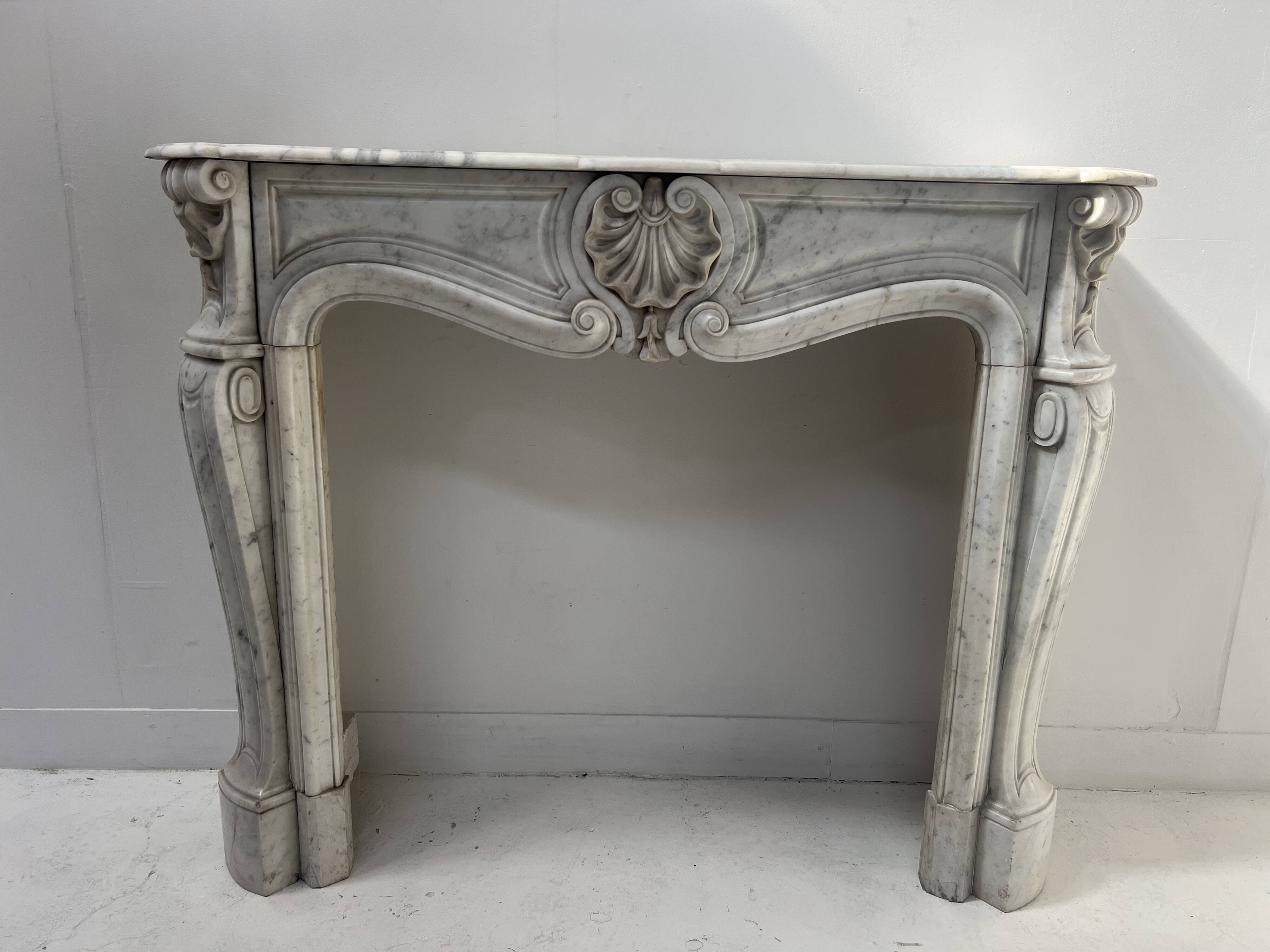 Louis XV style fireplace in veined white Carrara marble, 19th century.