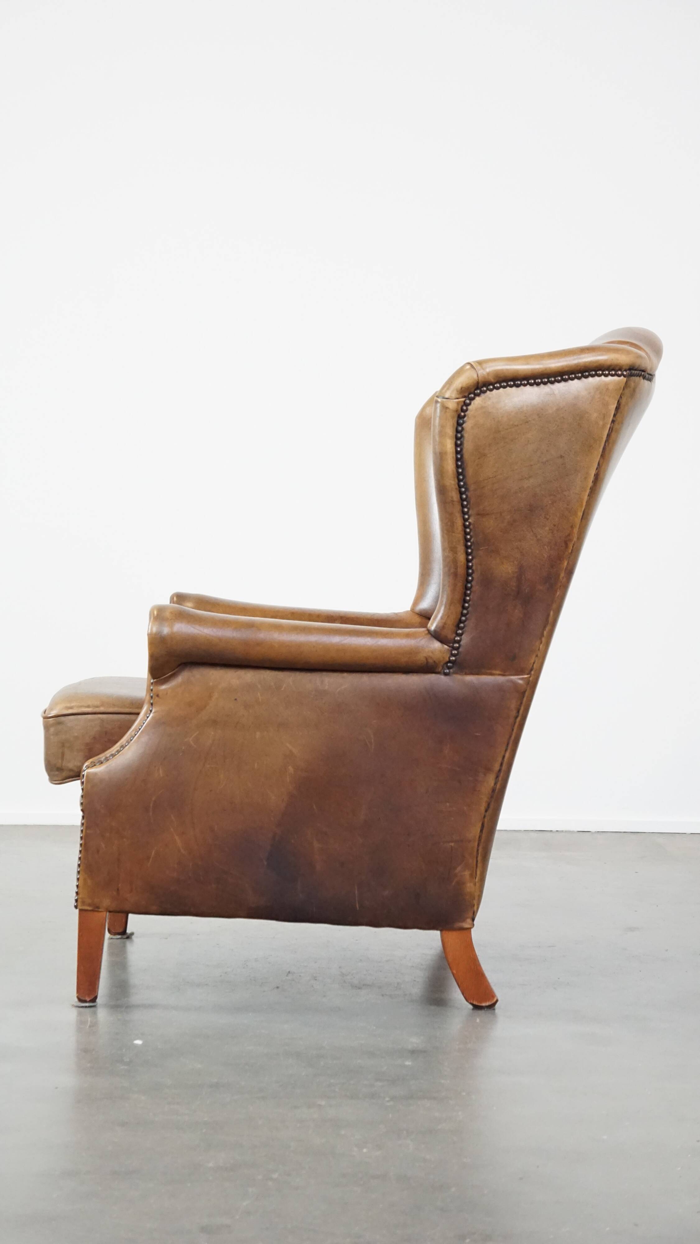 Charming sheep leather wingback armchair with a beautiful patina and excellent seating comfort