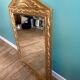 Mirror in gilded wood with a triangle pediment decorated with half sunflowers