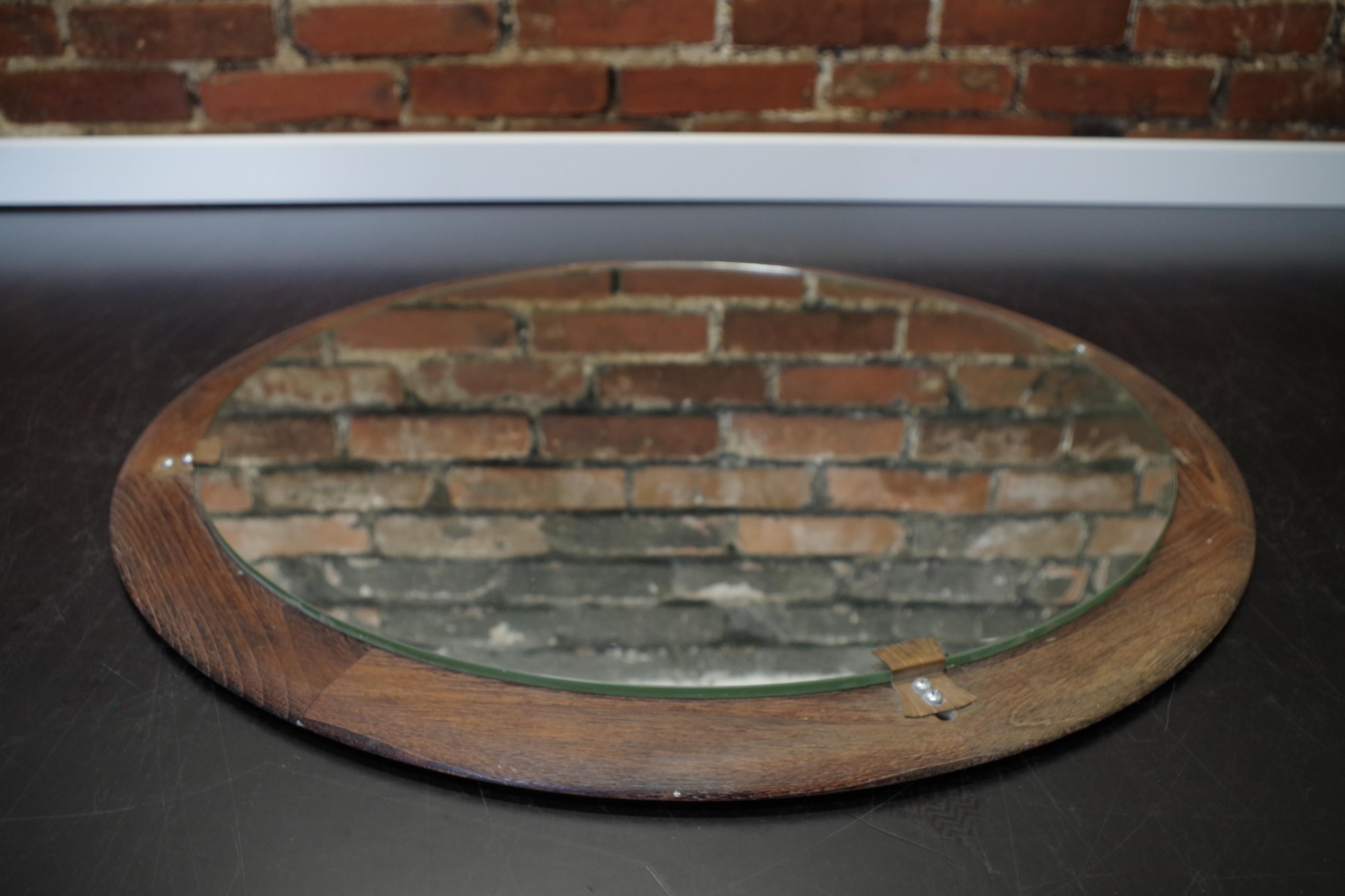 Round mirror in a vintage teak wood frame