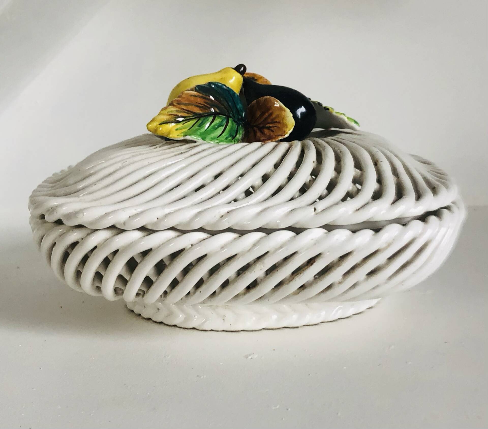Covered basket in white woven ceramic and fruit slip.