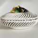 Covered basket in white woven ceramic and fruit slip.