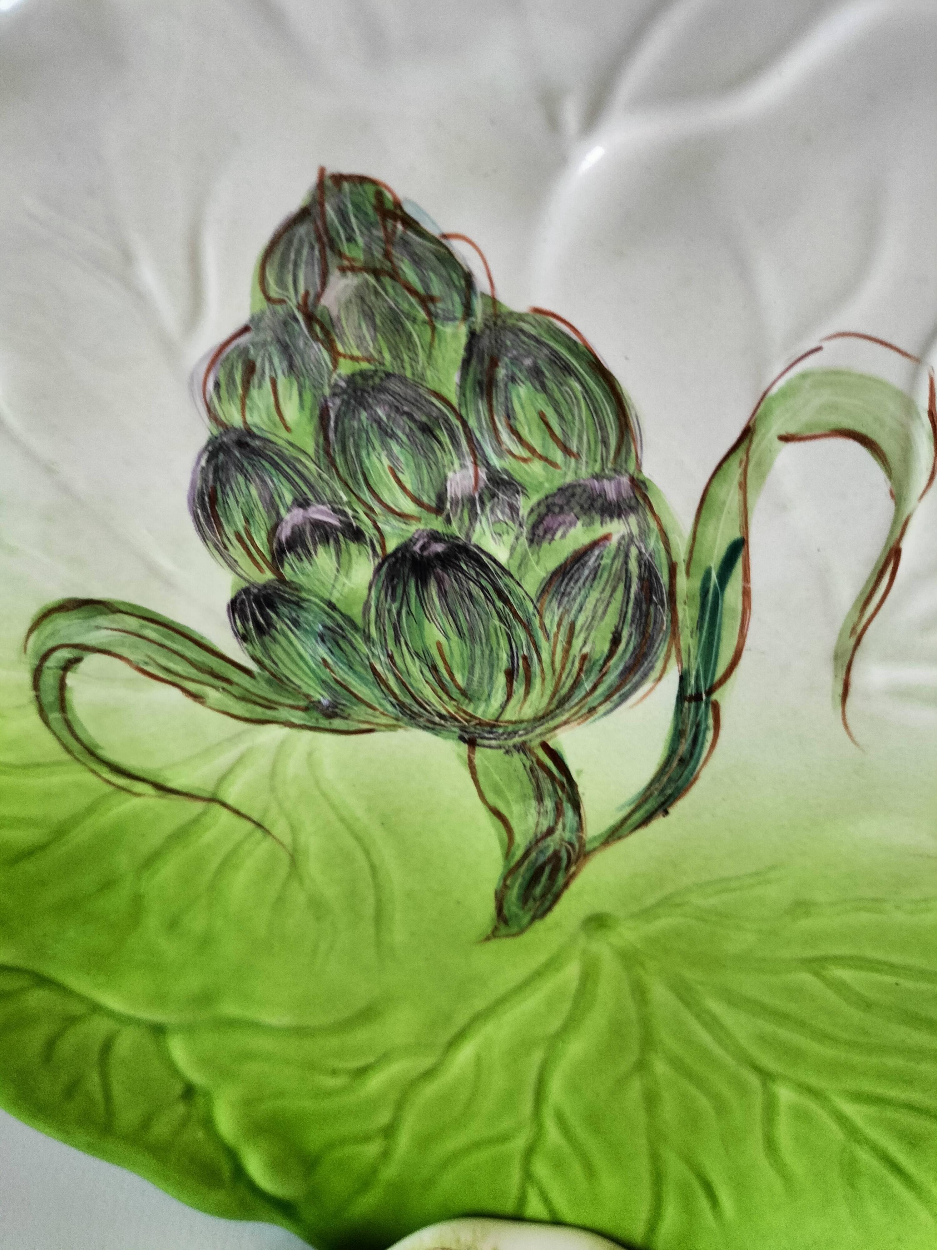 4 hand-decorated earthenware plates with vegetable and green leaf designs.