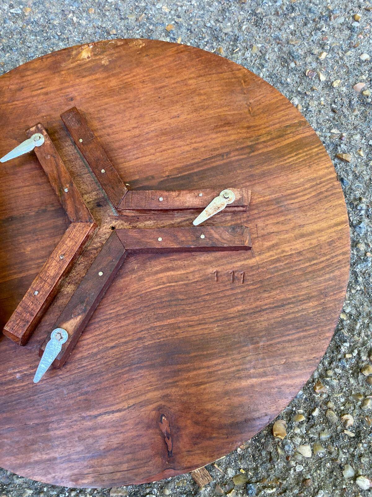 Round folding side table made of carved solid wood.