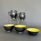 Two pitchers and three Elchinger ceramic bowls black and yellow background 1960