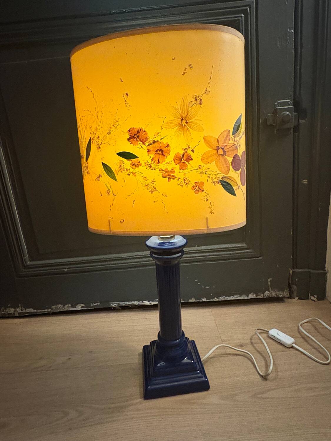 Corinthian column lamp base in blue with a lampshade of dried flowers.