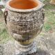 Large Cretan jar in terracotta with three handles on a stone base.