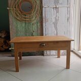 Coffee table with raw wood and a large drawer.