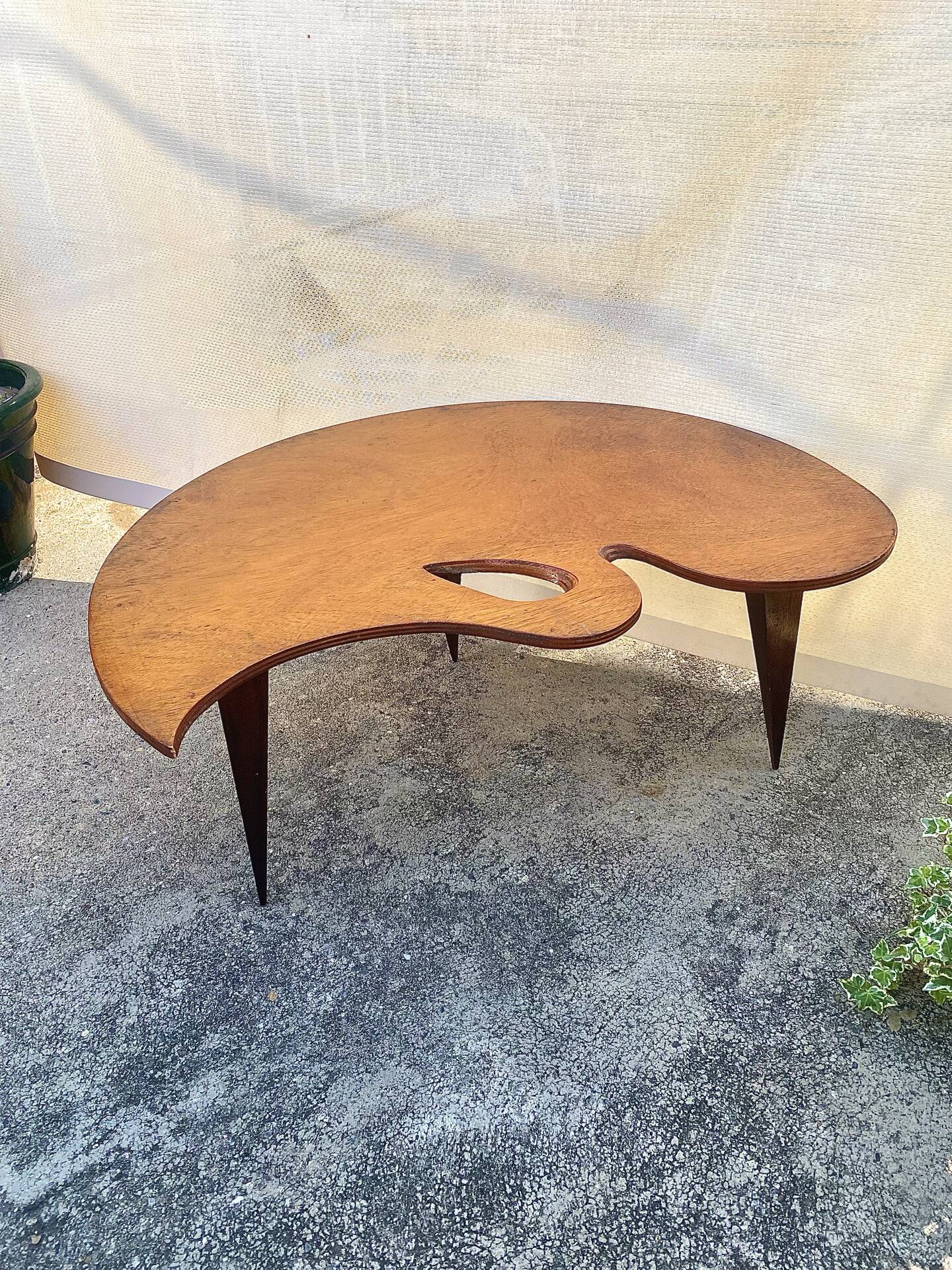 Mid-century coffee table with a palette shape and splayed legs.