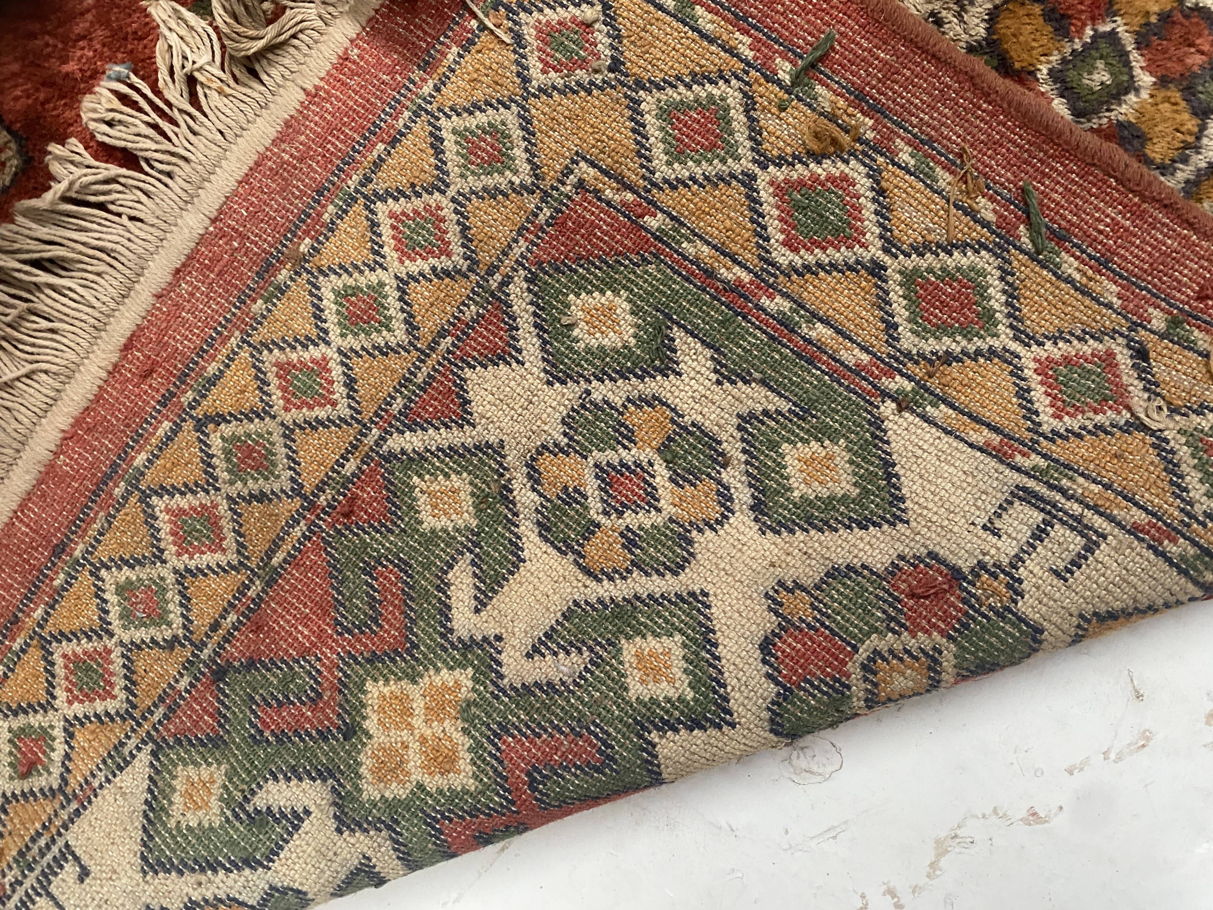 Antique wool rugs with designs on a red background, 20th century.