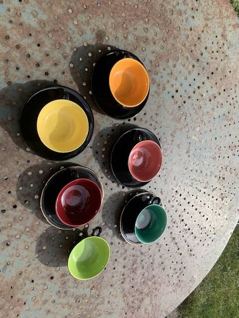 Coffee service composed of 5 cups and saucers in black earthenware and different colored interiors