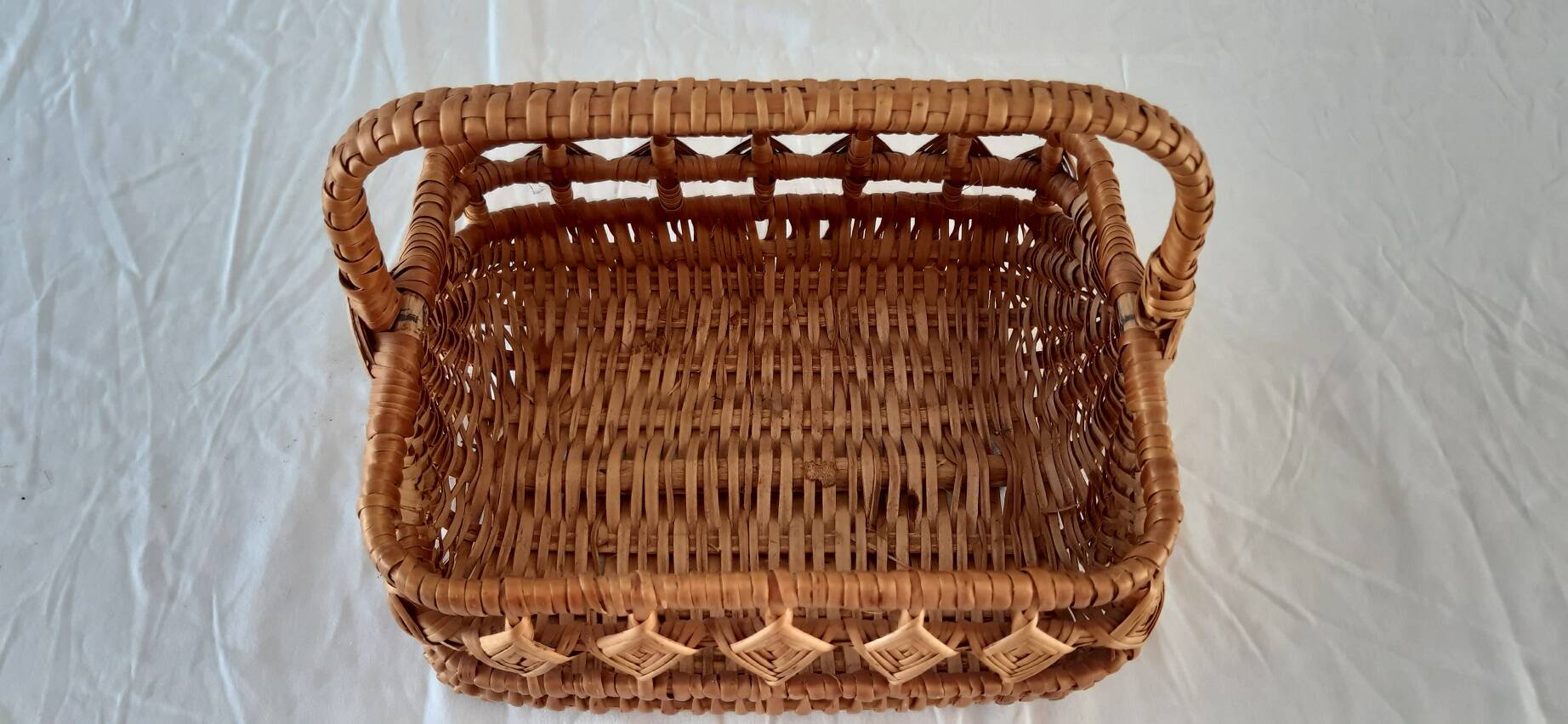 Old wicker basket with diamond-shaped decorations