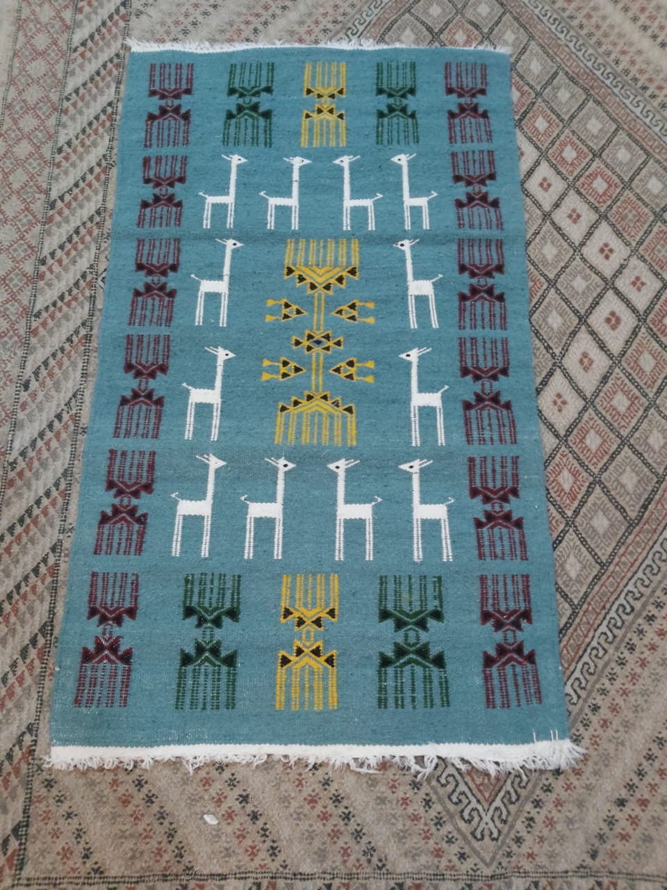 Blue carpet with gazelle patterns woven by hand