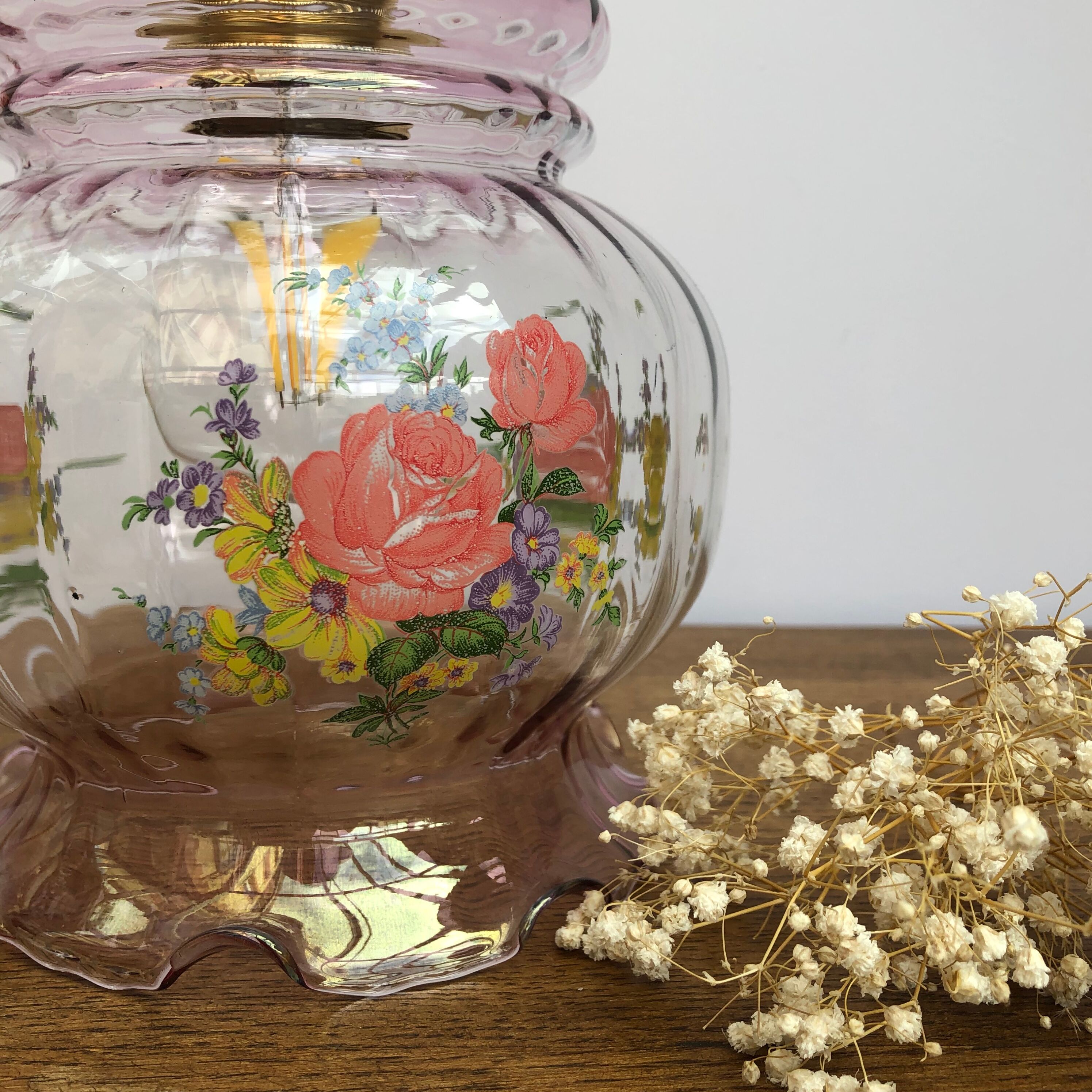 Vintage pink glass hand lamp with flower motifs