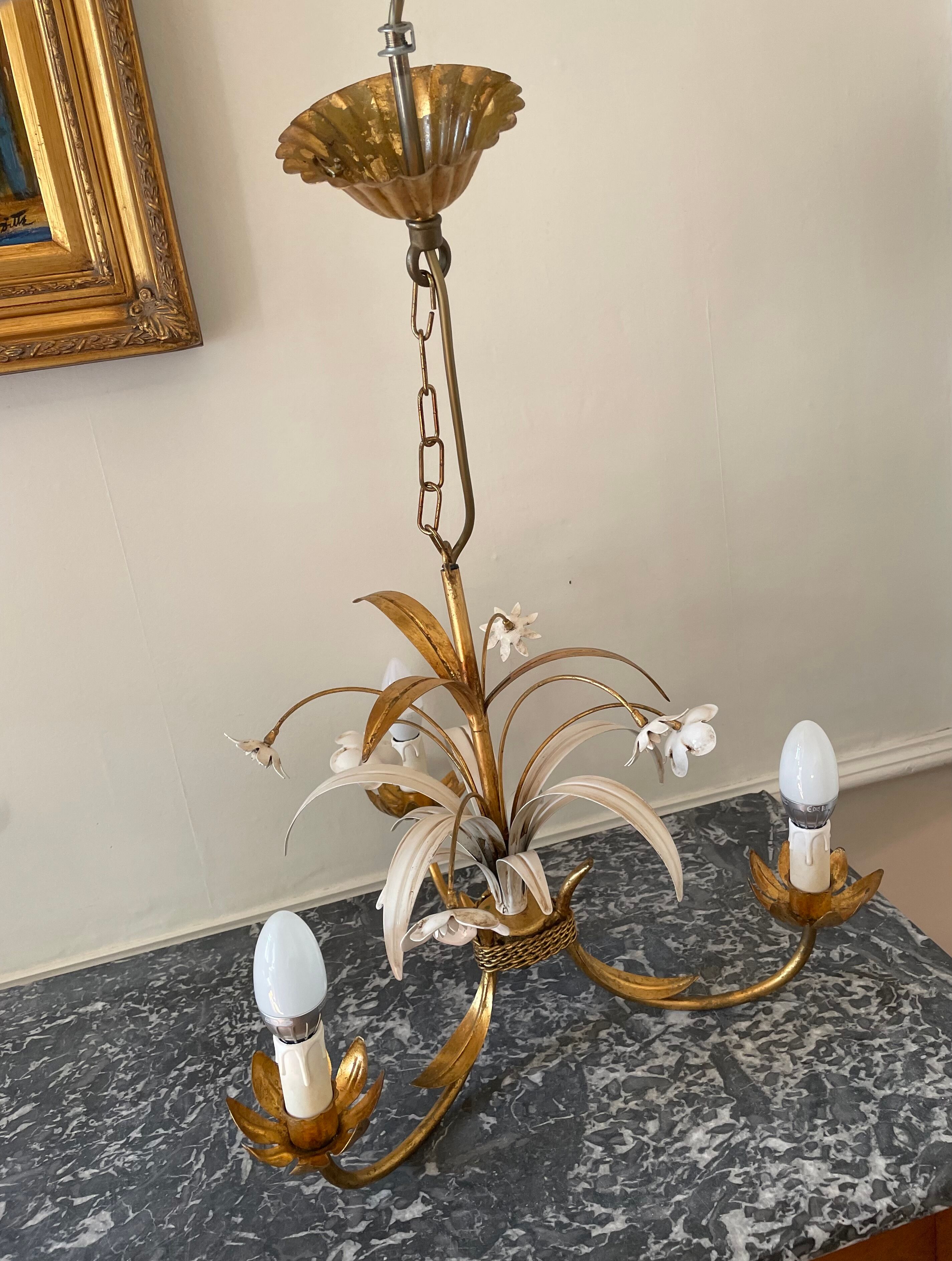 Golden metal chandelier decorated with flowers