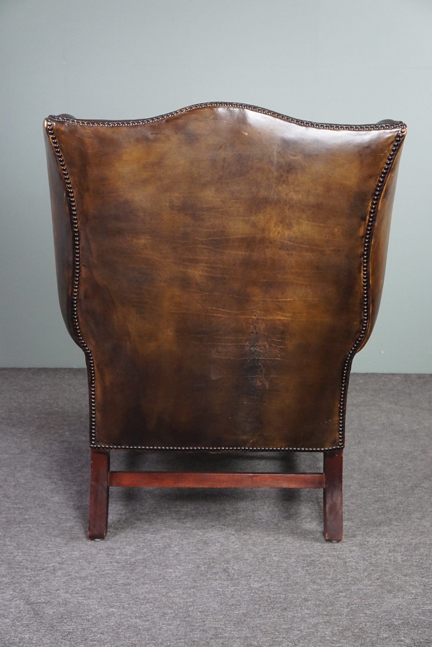 Patinated cowhide leather armchair