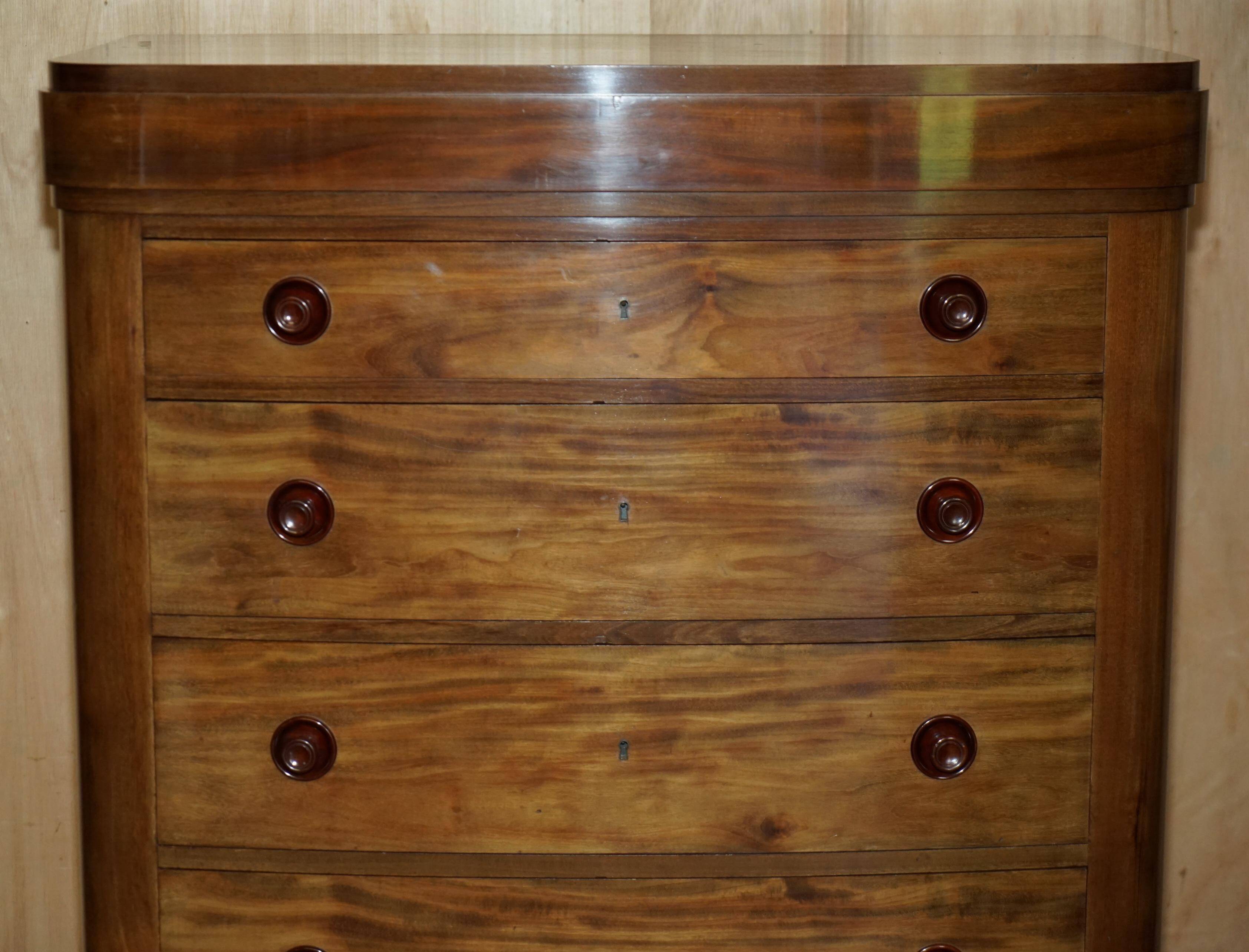 Pair of tall walnut chests of drawers with curved fronts in country style.