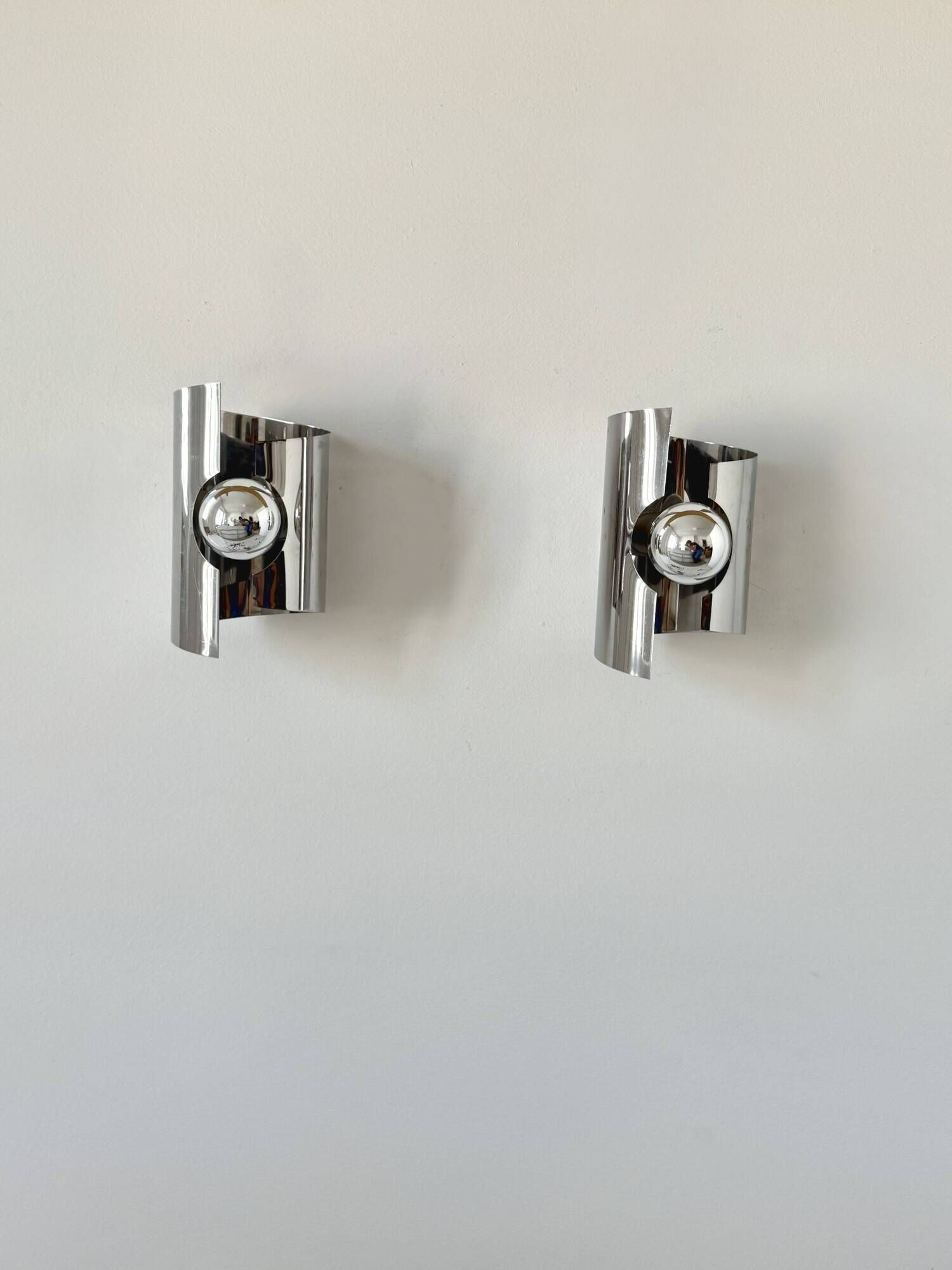 Pair of vintage wall lights, curved chrome metal, France, 1970.