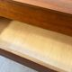 Vintage wooden chest of drawers with tapered legs.