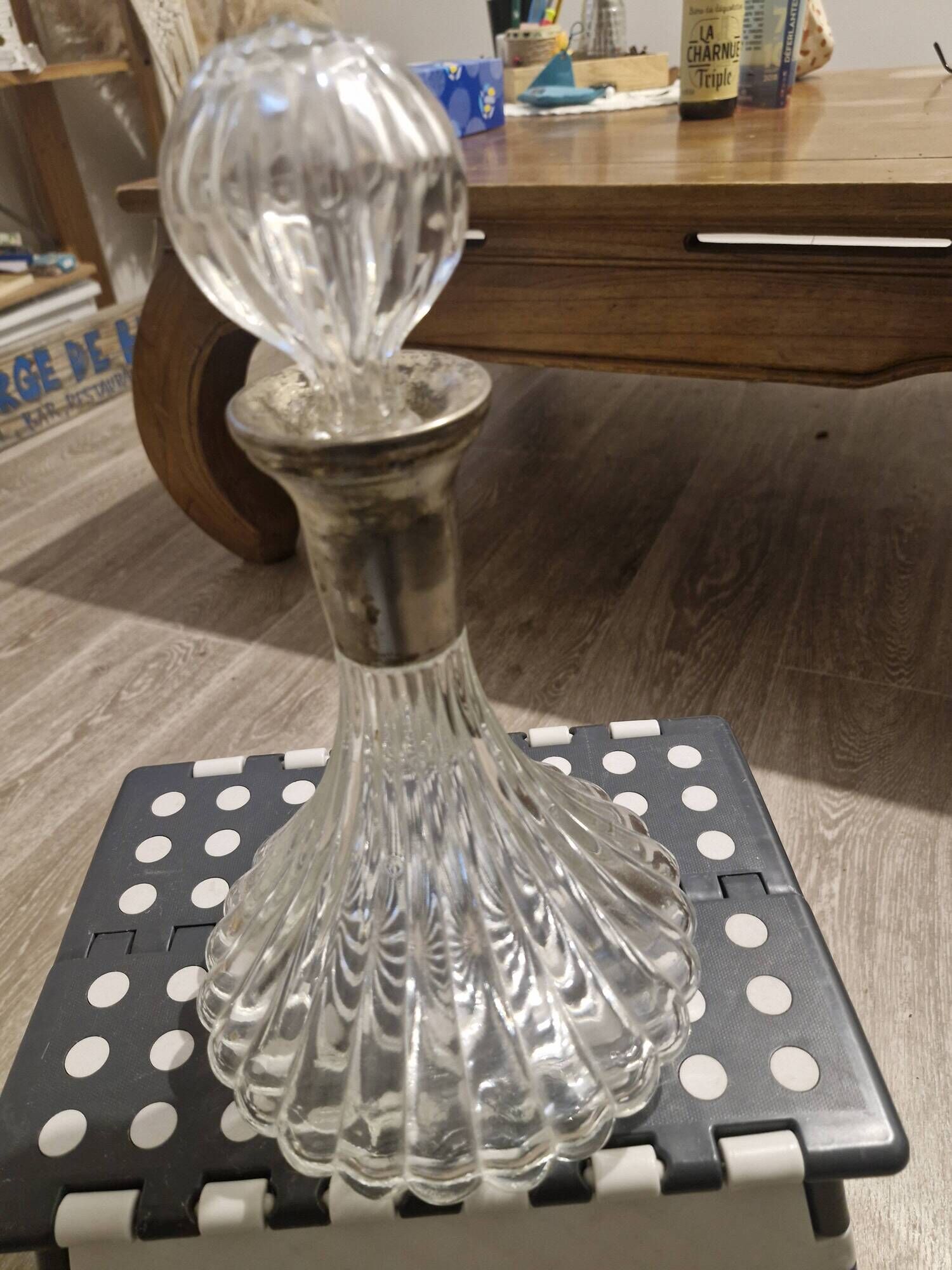 Antique cut glass spirit decanter with silver-plated neck and spout.