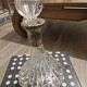 Antique cut glass spirit decanter with silver-plated neck and spout.