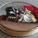 Old round box with decoration fixed under glass