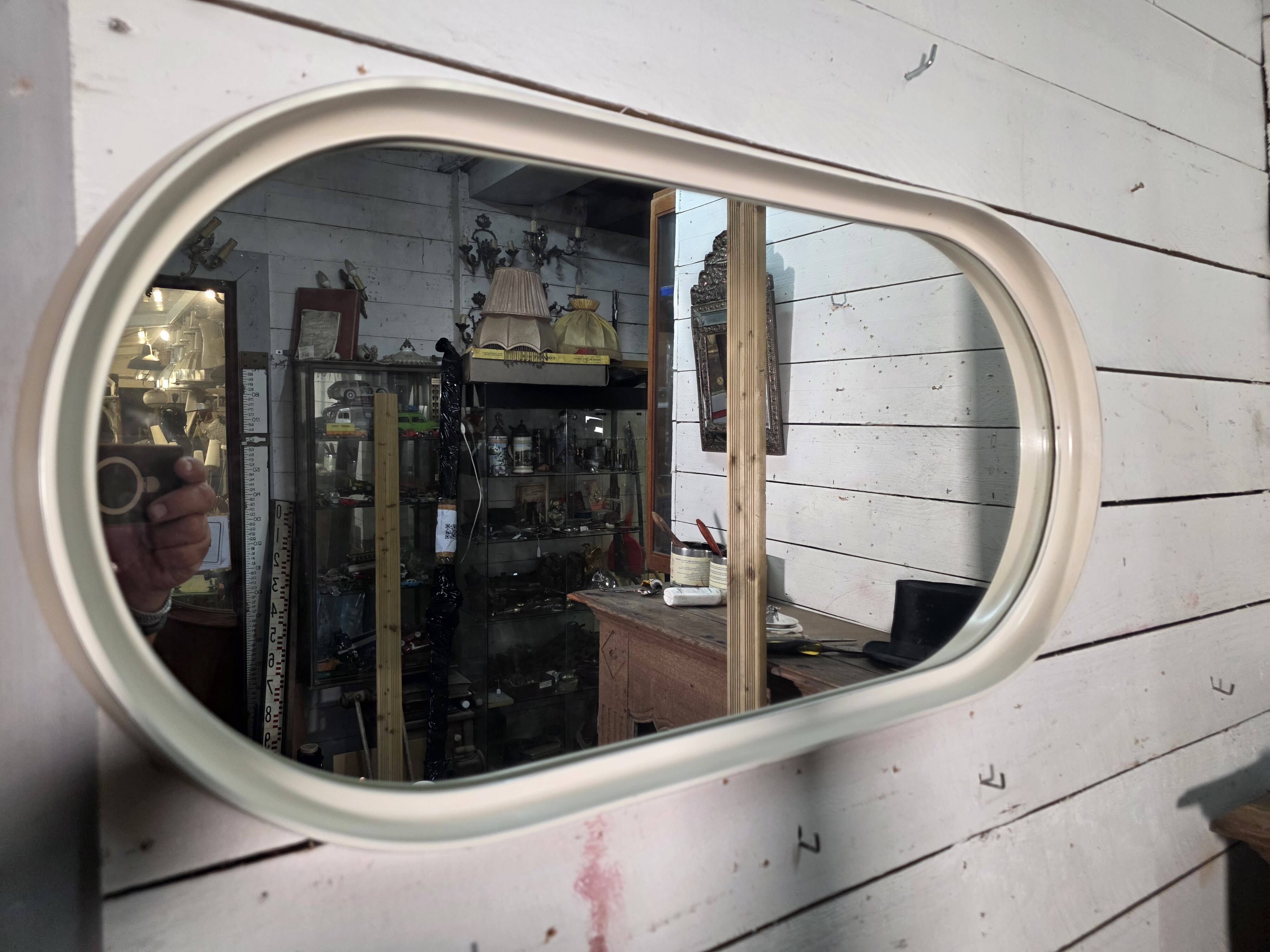 Oval mirror in white lacquer from the 1970s.