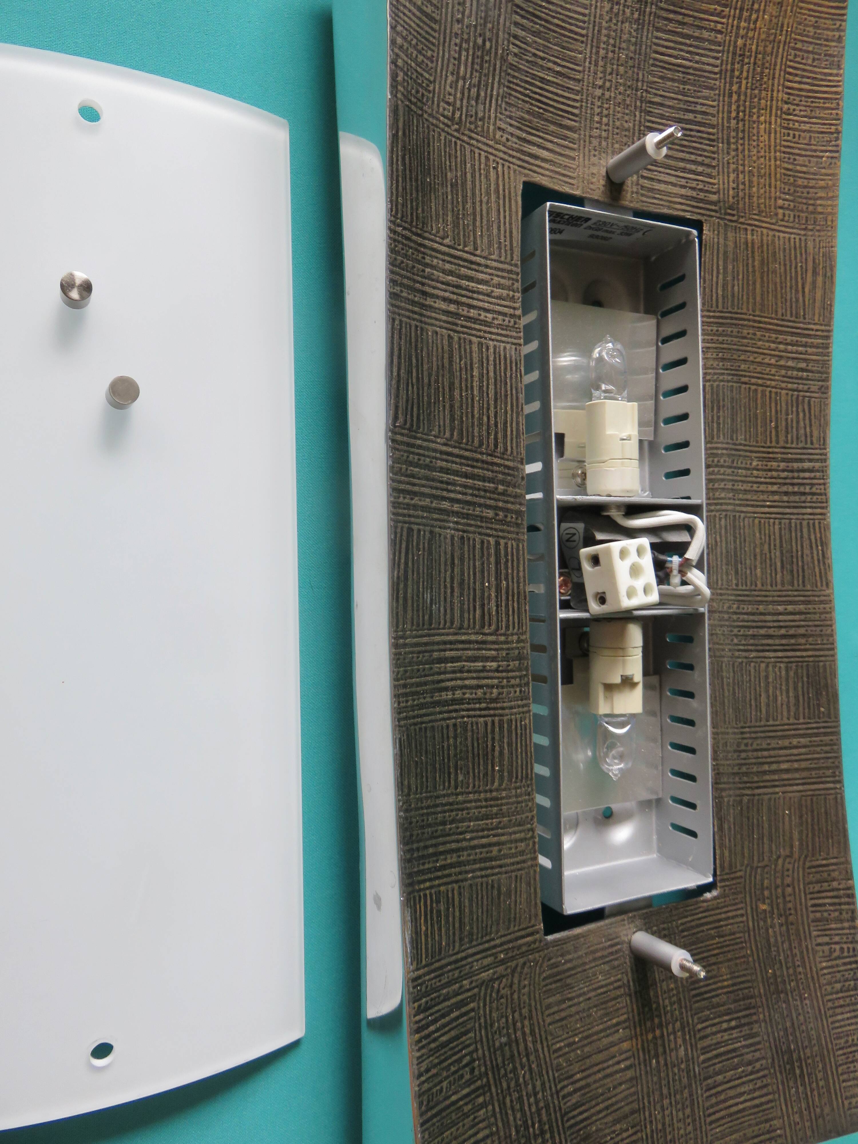 Pair of wall sconces in gold-plated alloy with bas-relief and opaline glass. Germany, 1980