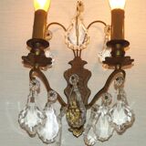 Pair of French antique brass double wall lights with assorted crystals.