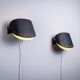 Matte black wall lamps with perforated shades and brass details