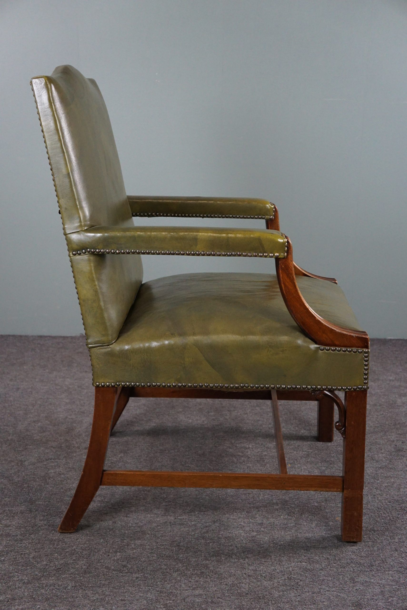 Elegant armchair and footrest in English green leather
