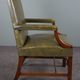 Elegant armchair and footrest in English green leather