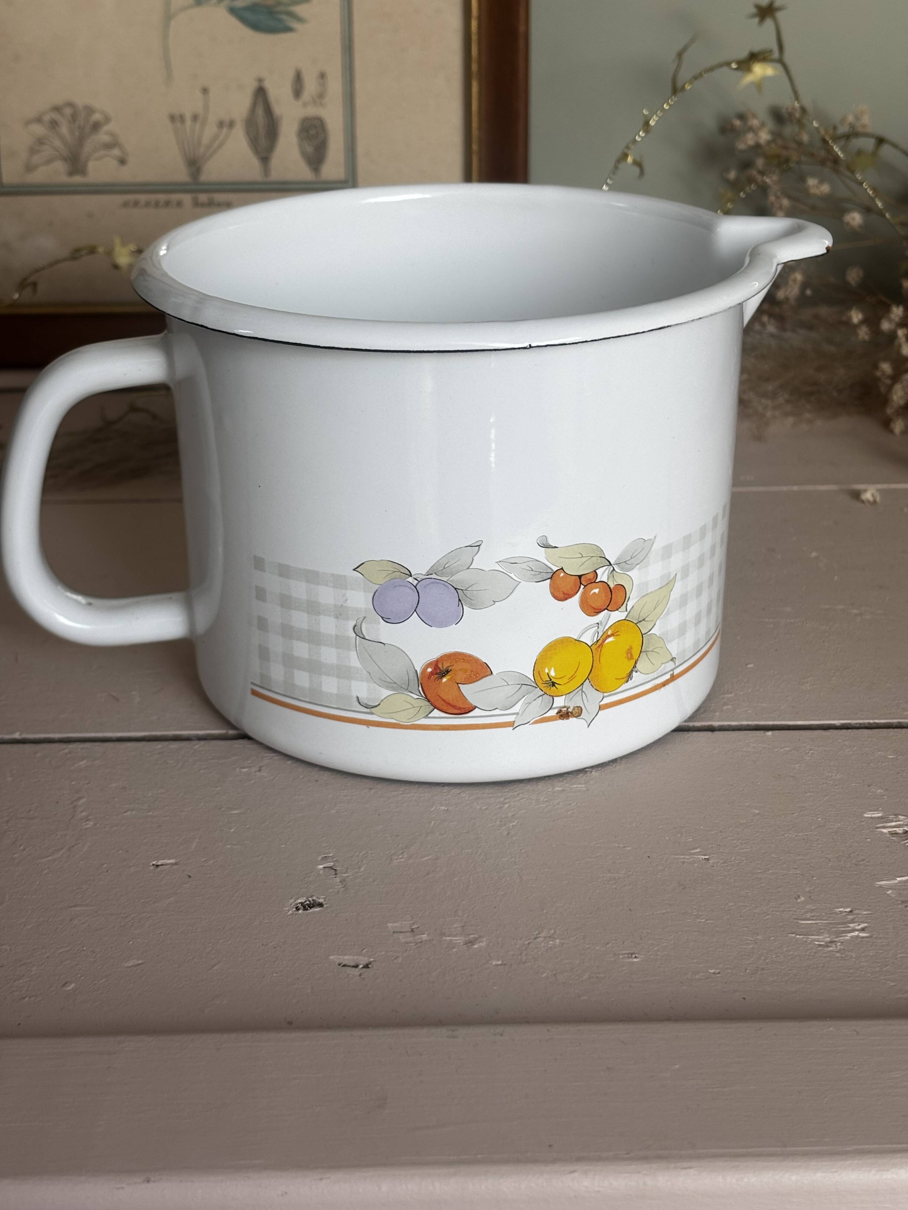Vintage enamelled white metal milk jug with fruits.