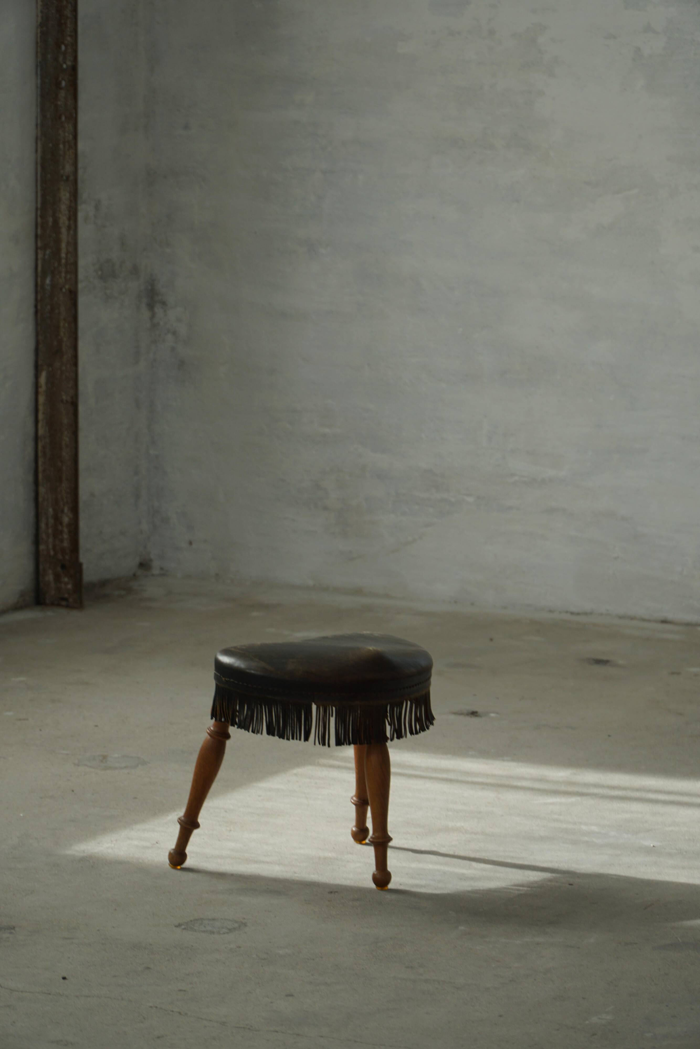Danish oak tripod stool from the early 20th century with leather fringe, 1930s.