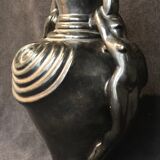 Black ceramic vase caught in naked women's bodies