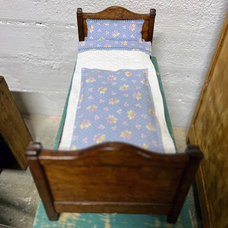 Old doll's bed in varnished wood