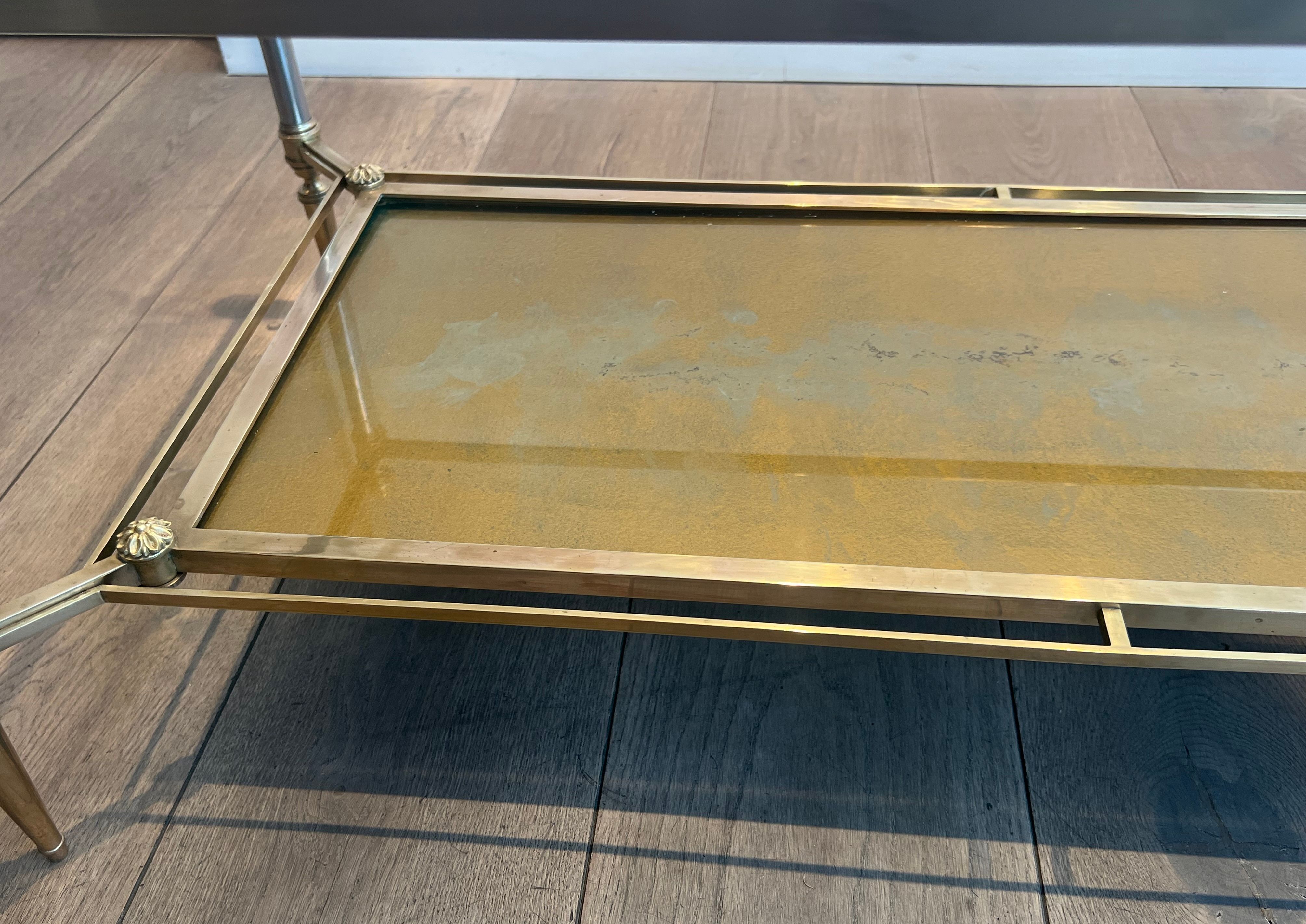 Coffee table in brass, brushed steel, glass, and gilded eglomisé mirror from Maison Jansen.