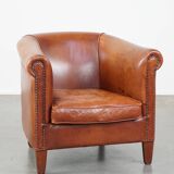 Cognac-colored cow leather club chair finished with decorative nails in English style