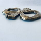 Bow-shaped brass trivet