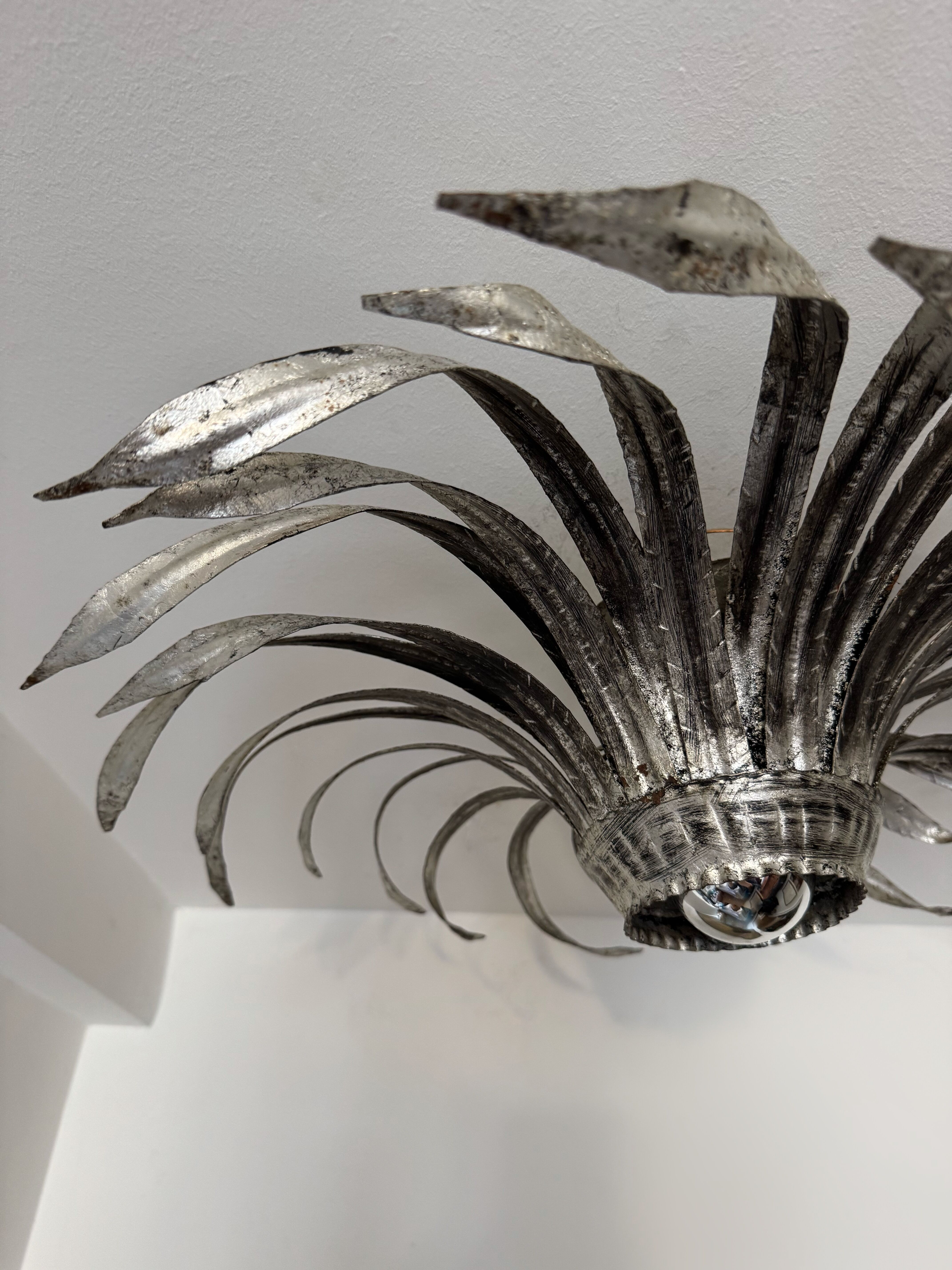 Silver wrought iron sunburst wall light from the 1960s.