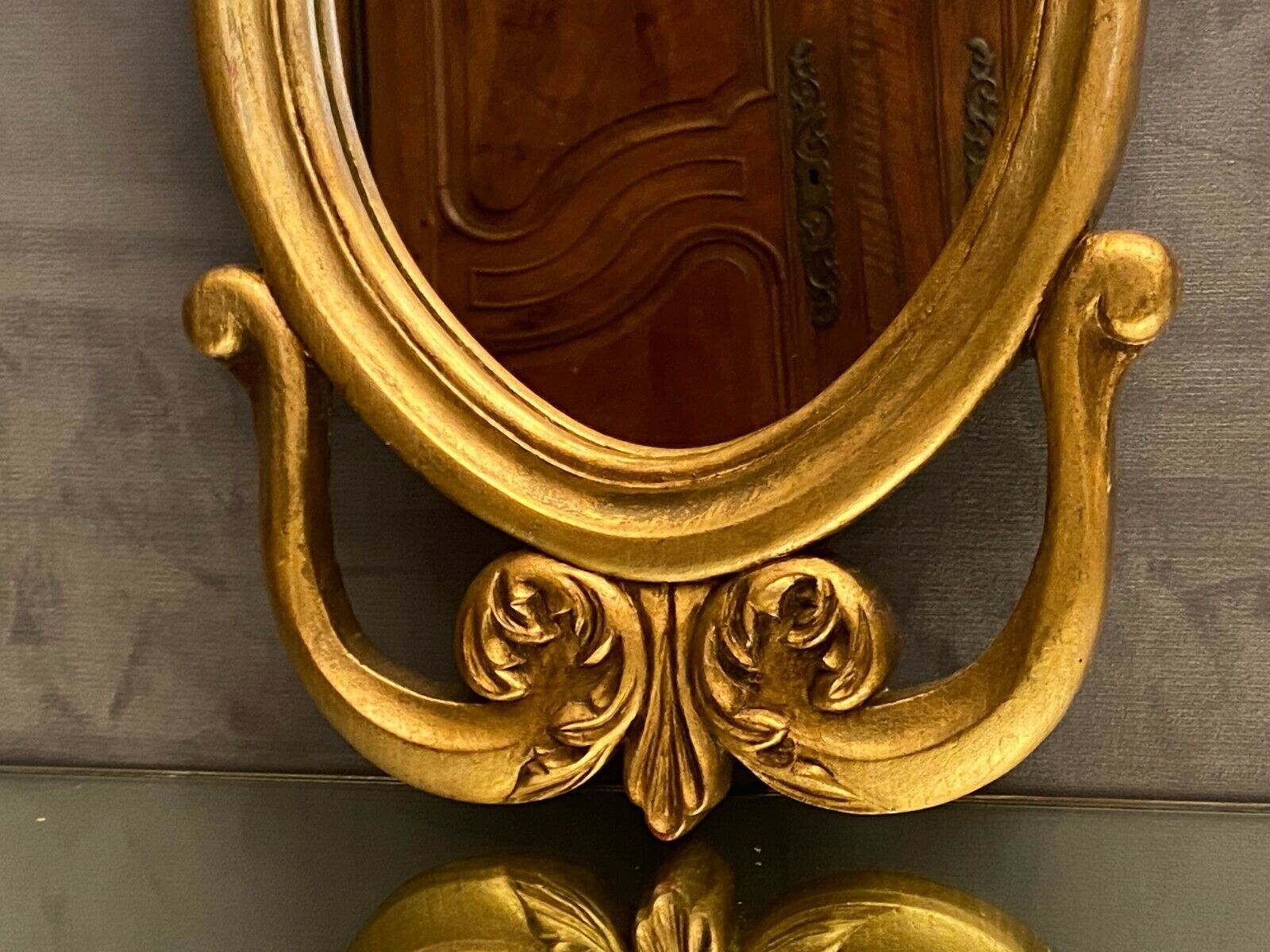 Oval view mirror in gilded wood with leafy decoration in Regency style