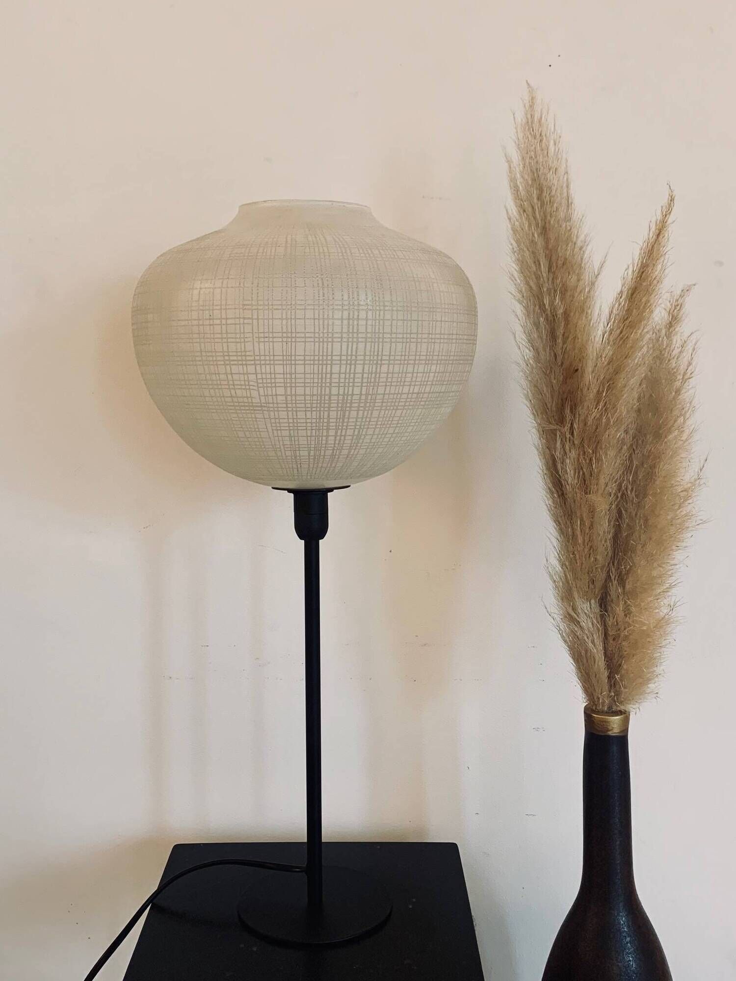 Table lamp with a white striped glass globe lampshade and a gold base