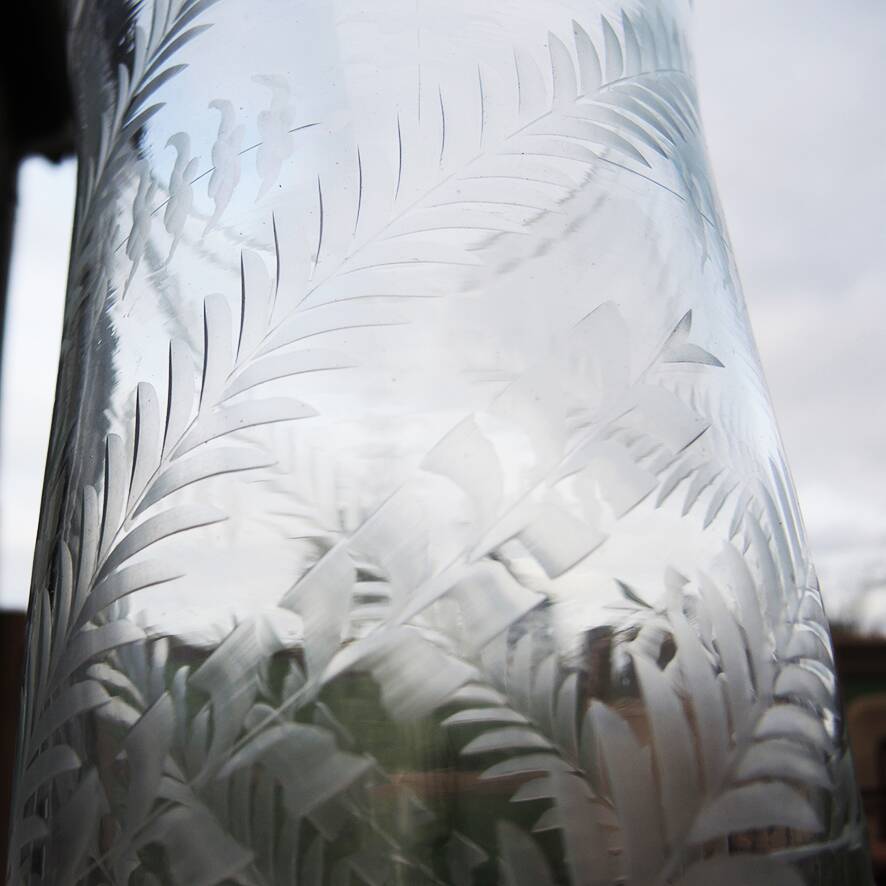 Ancient transparent glass vase with engraved plant decoration.
