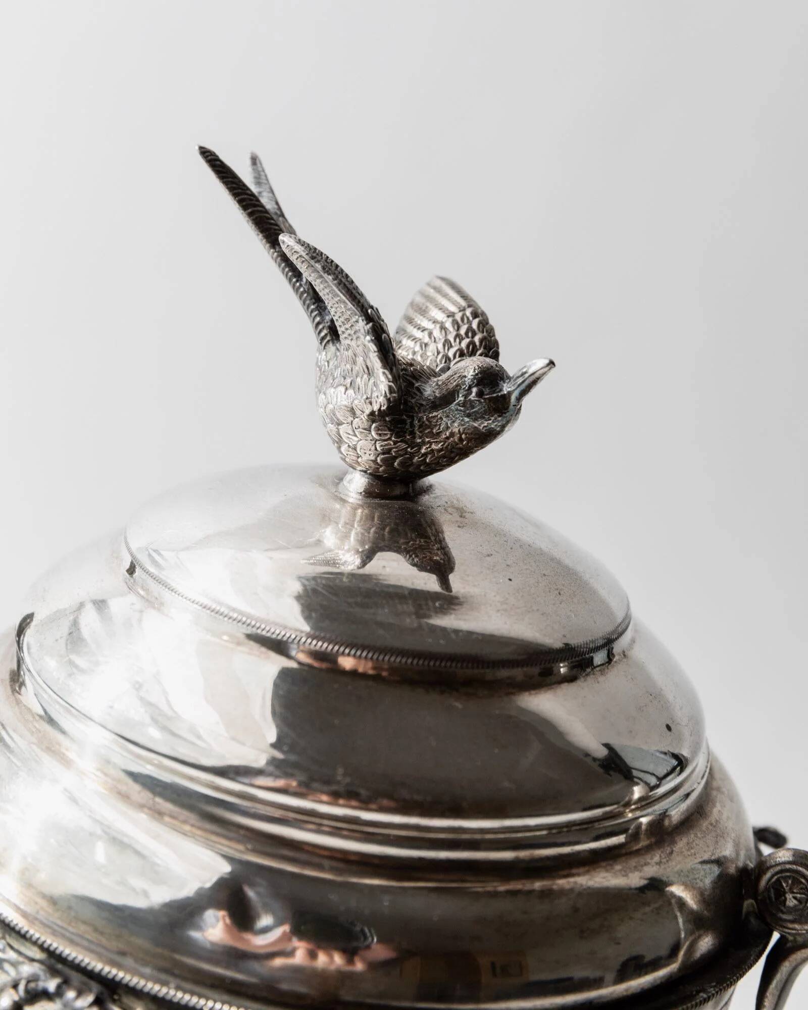Vintage 1930s silver-plated footed bowl with lid by Warren Rogers New York, featuring a bird motif and ornate details.