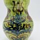 Green stoneware pitcher with flower and brown bird decoration