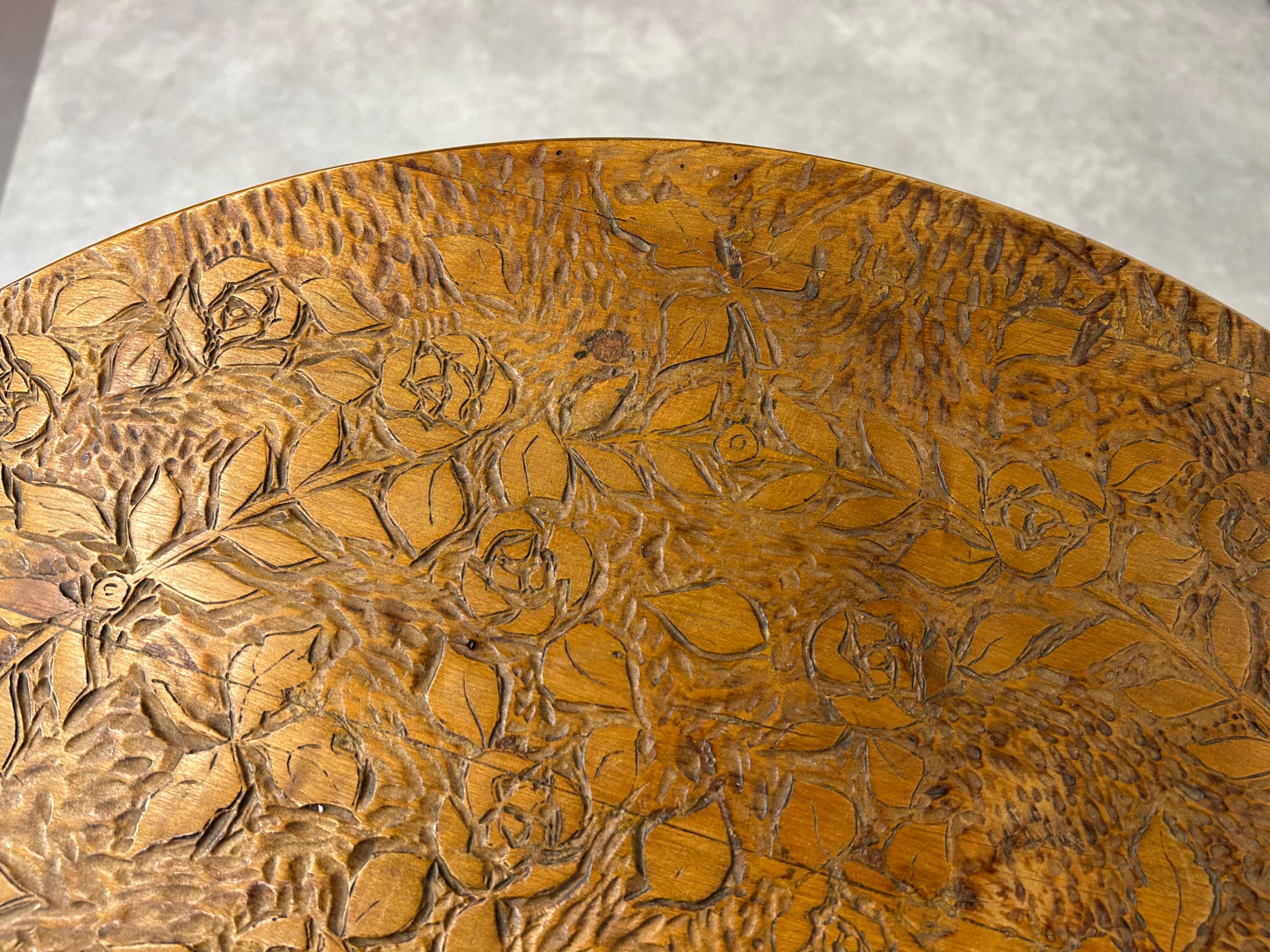 Round Art Nouveau coffee table with a sculpted top.