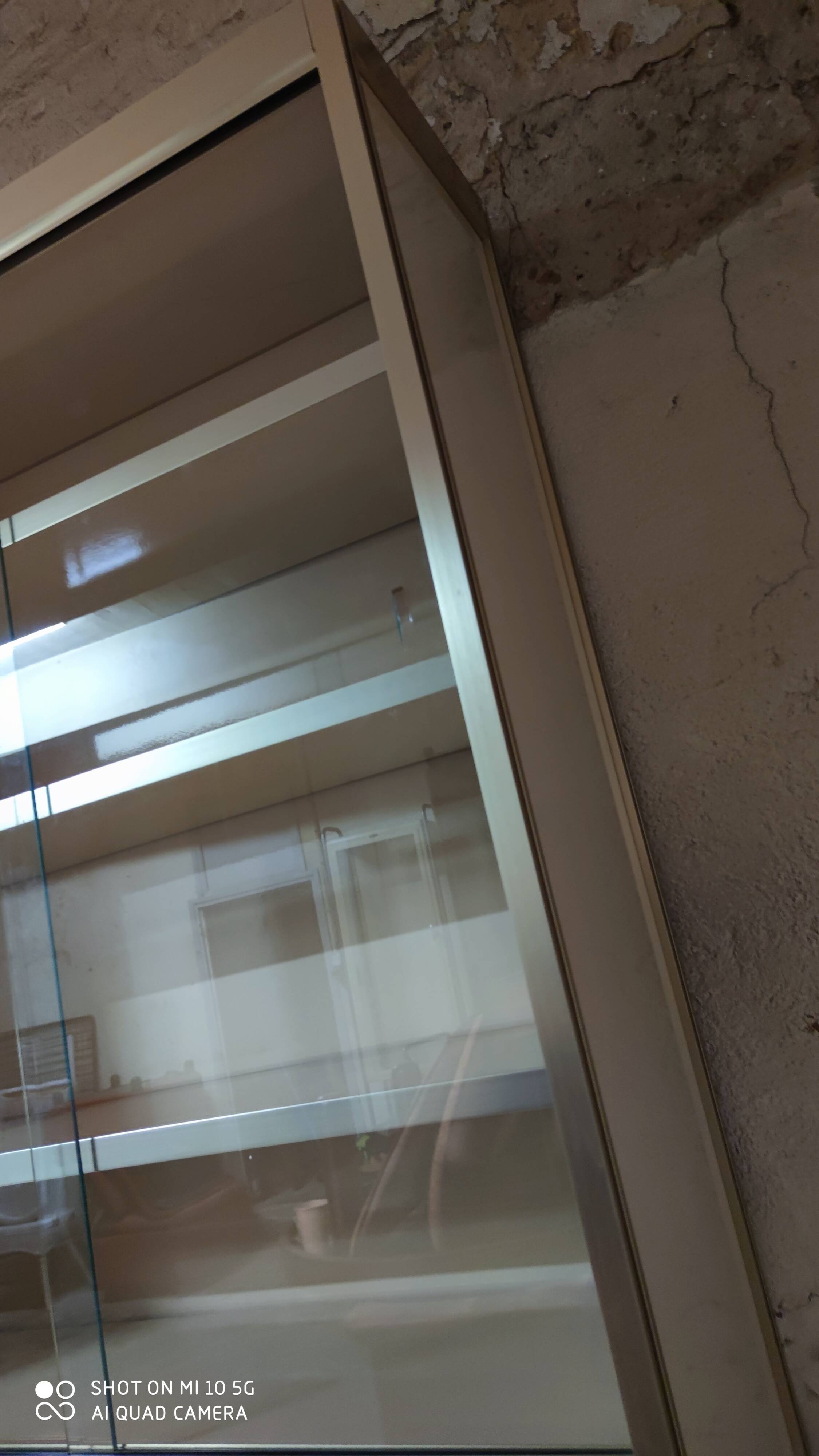 Ivory-colored and matte gold anodized aluminum display bookcase